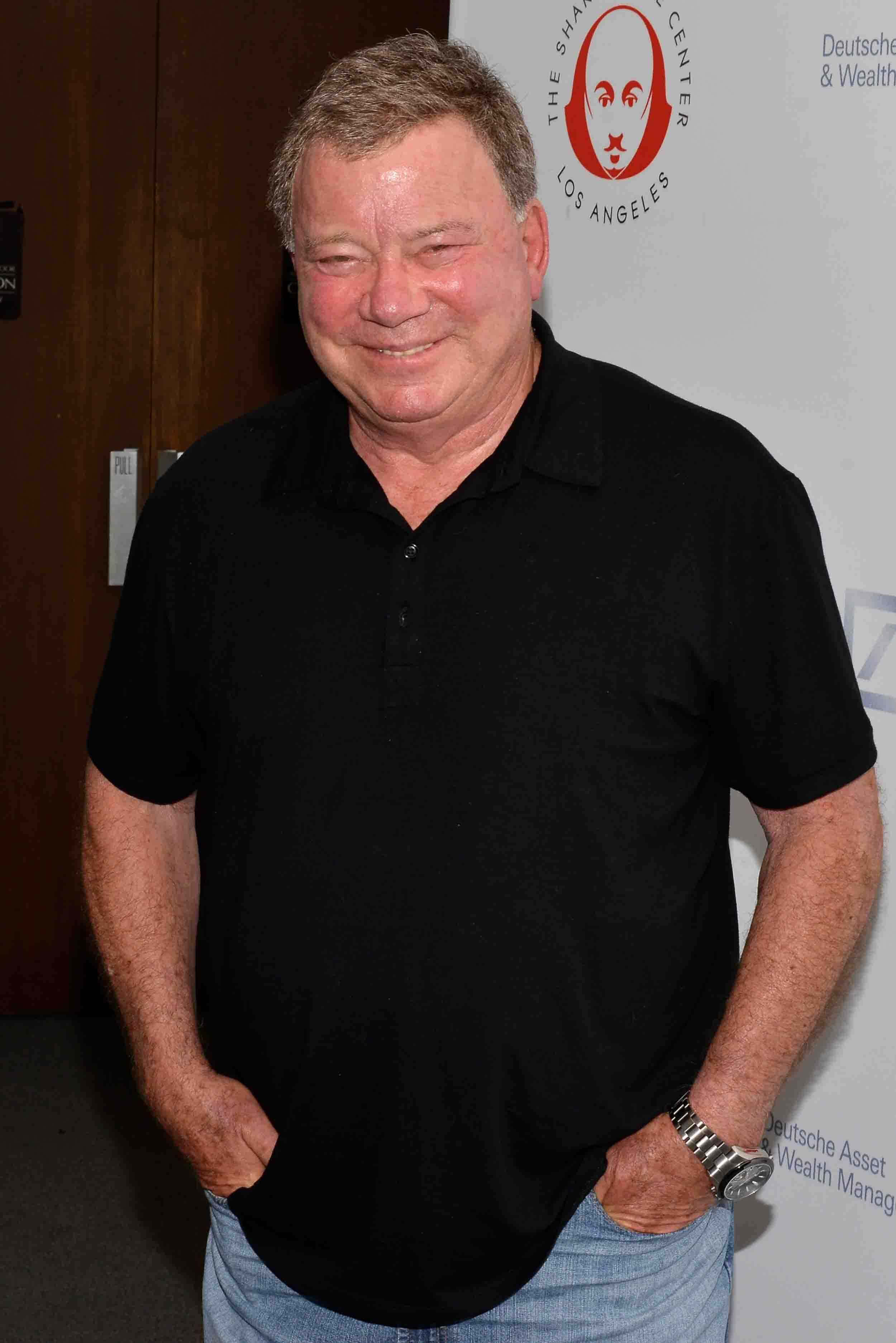 William Shatner, black polo shirt, jeans, 2K Phone Wallpaper