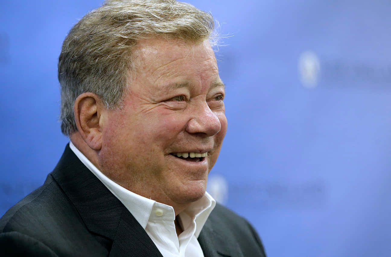 William Shatner, dark suit, blurred blue background, HD Desktop Wallpaper