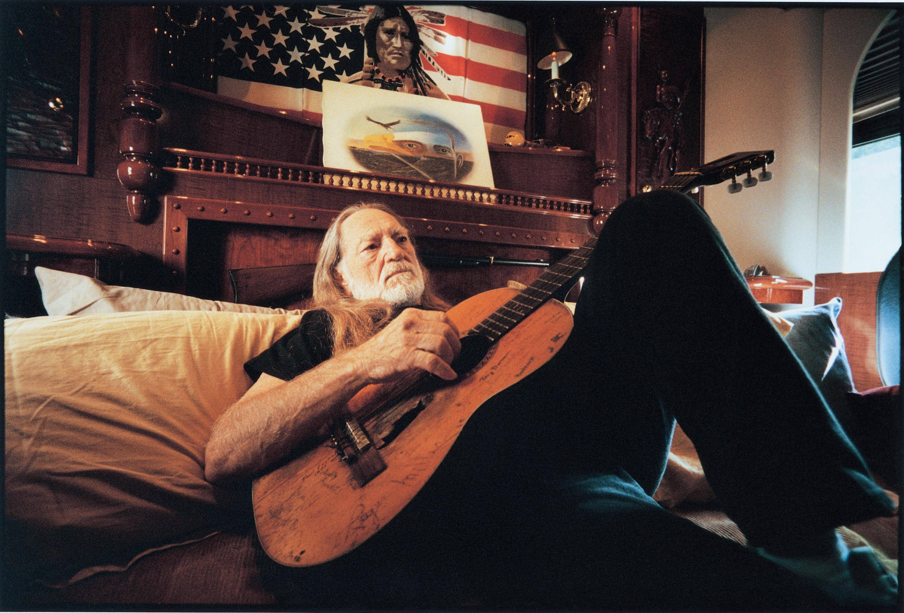 Willie Nelson, wooden guitar, bed, 2K Desktop Wallpaper