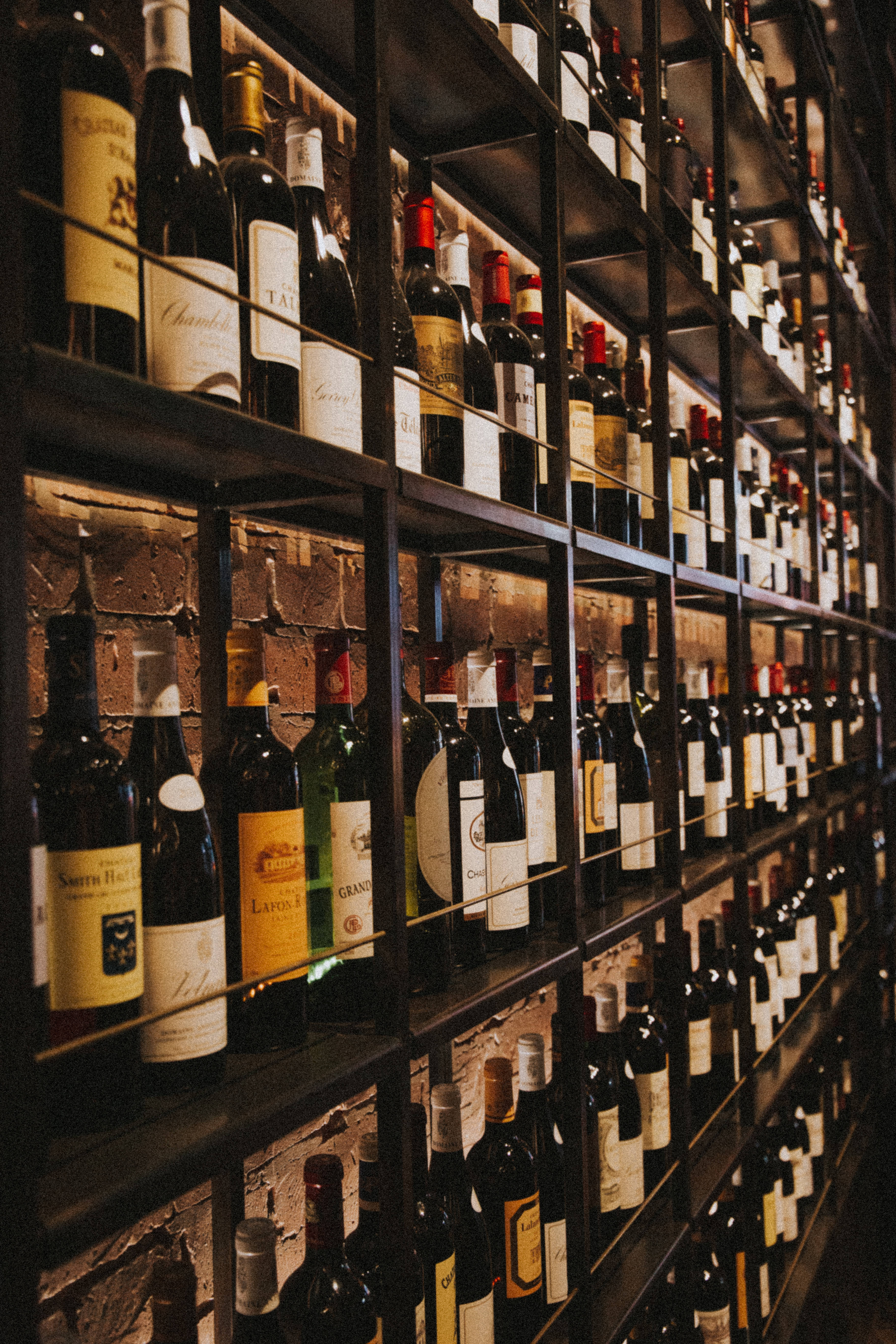 wine bottles, dark metal shelves, rustic brick wall, 5K Phone Wallpaper