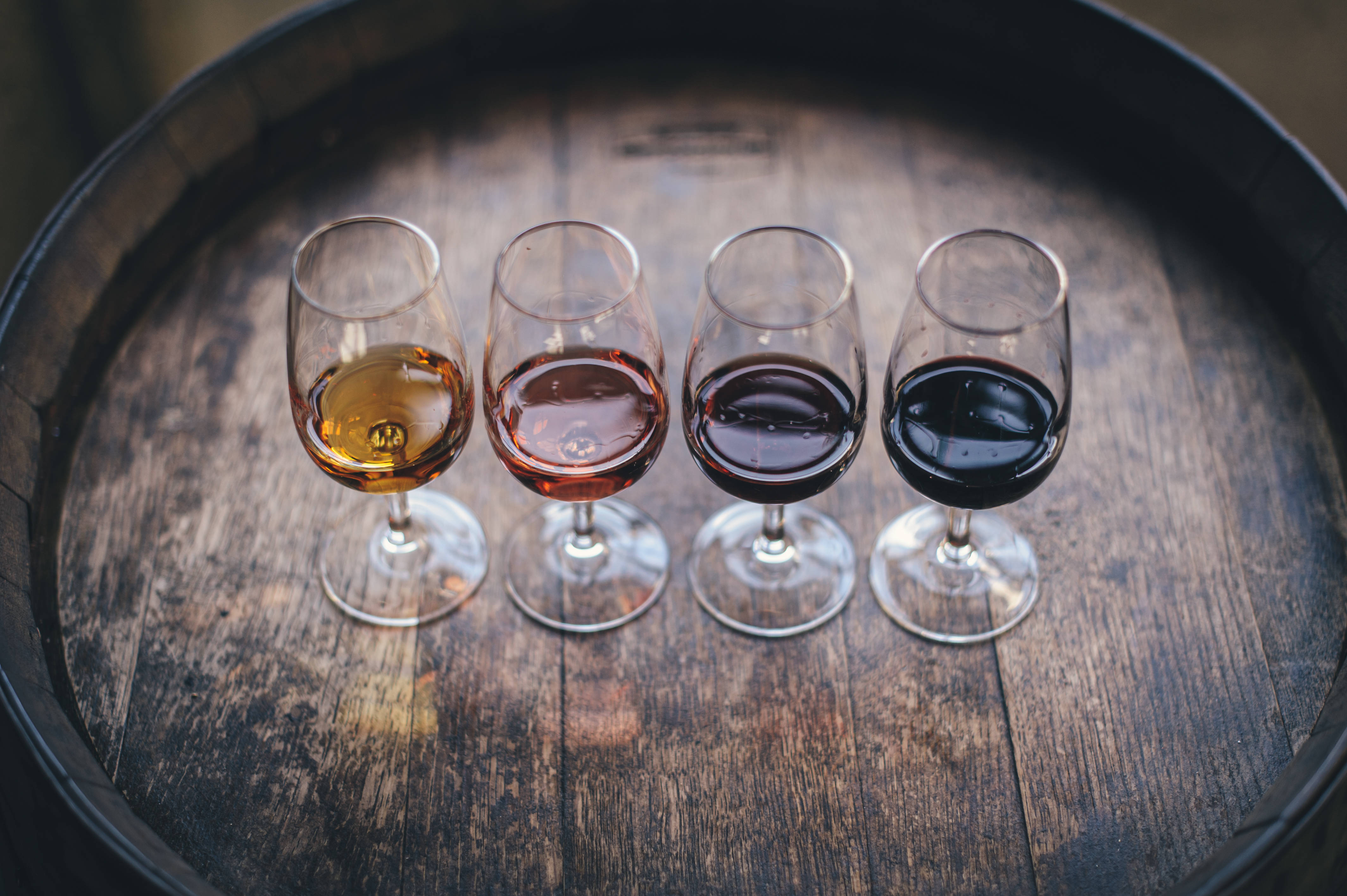wine glasses, varying shades of wine, weathered wooden barrel top, 4K Desktop Wallpaper