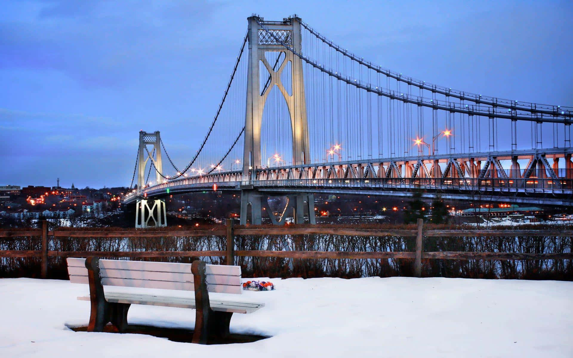 Winter Cityscape, snow-covered bench, lit suspension bridge, Full HD Desktop Wallpaper