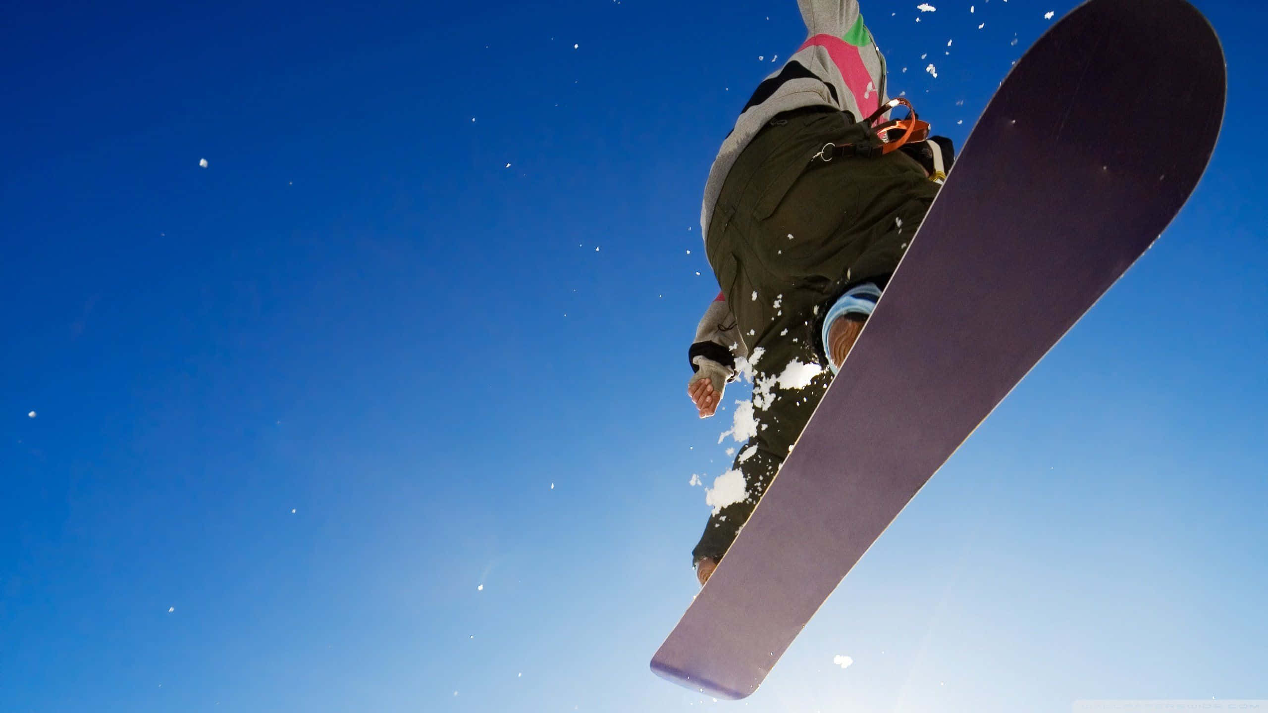 snowboarder, crisp blue sky, snow spraying from their board, 2K Desktop Wallpaper