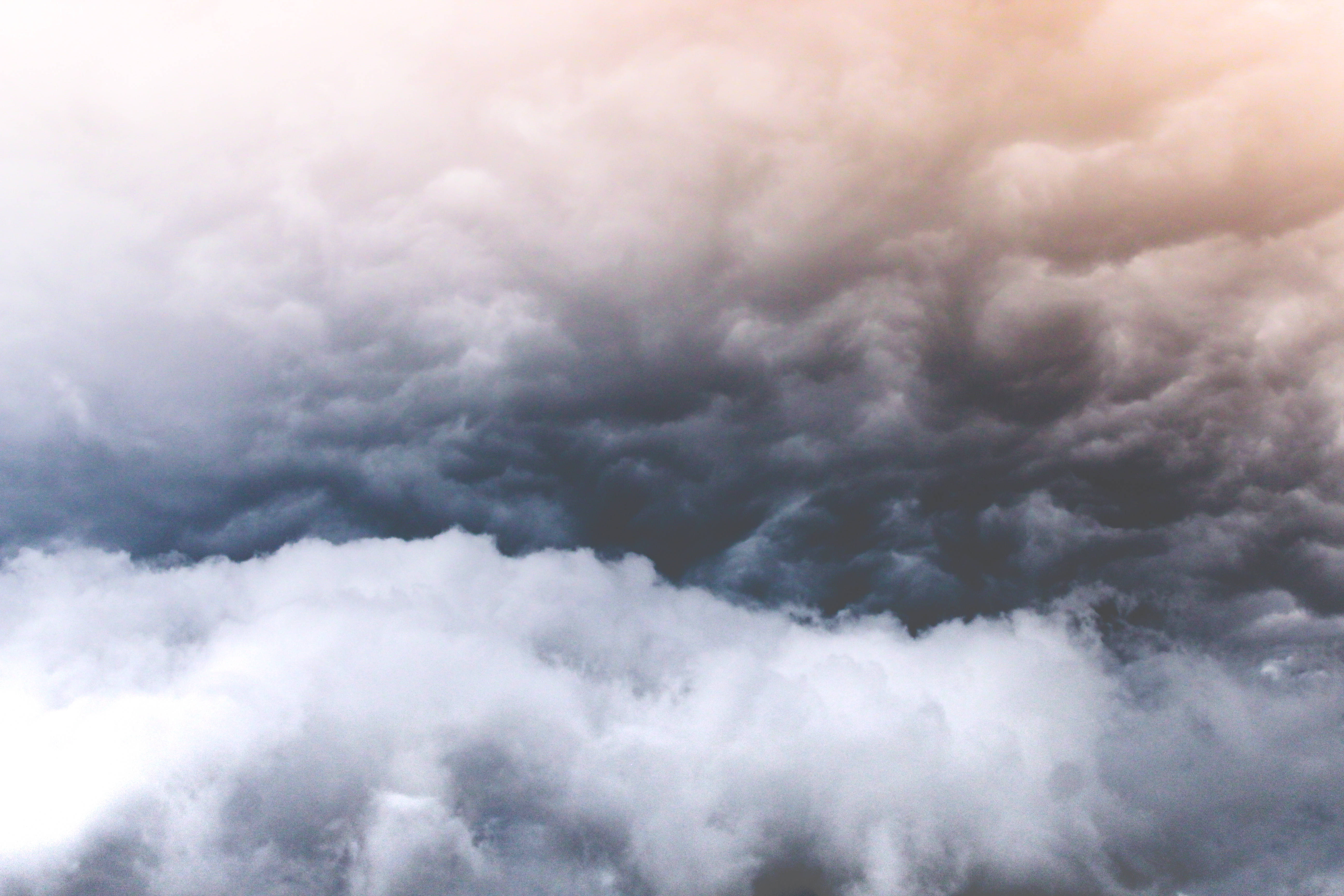 stormy sky, dark gray and white formations, warm golden light, 5K Desktop Wallpaper