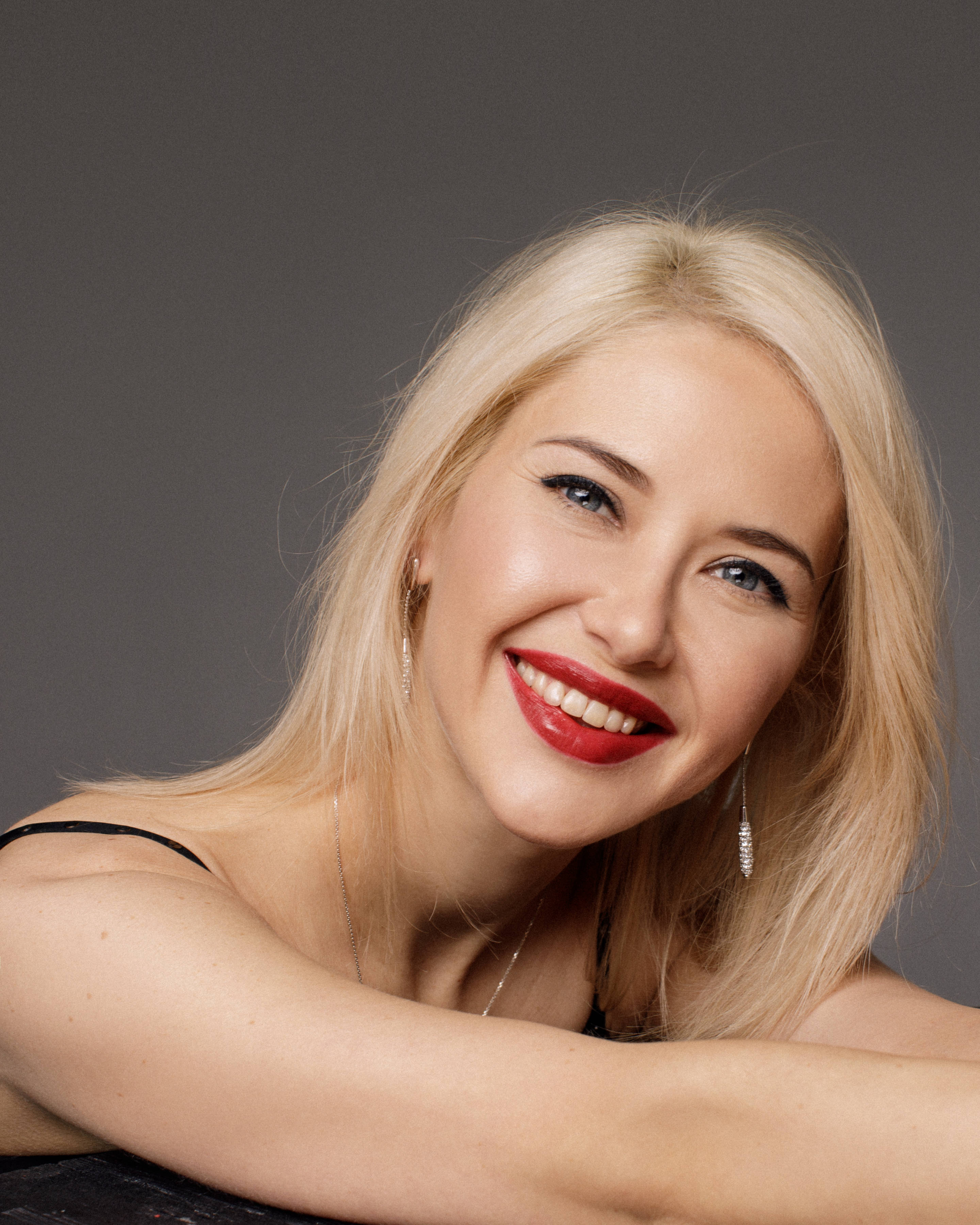 blonde woman, bold red lipstick, neutral gray studio backdrop, 2K Phone Wallpaper