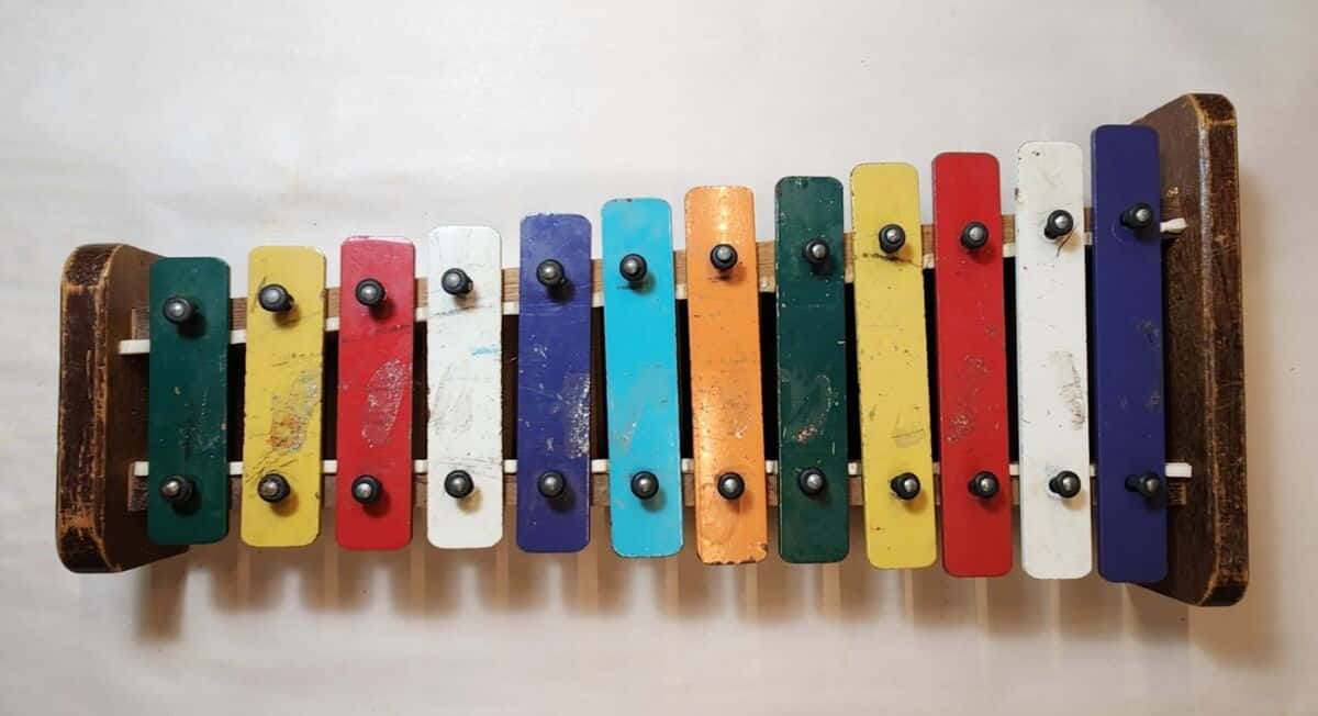 colorful xylophone bars, rainbow-colored keys, weathered wooden xylophone, SD Desktop Wallpaper