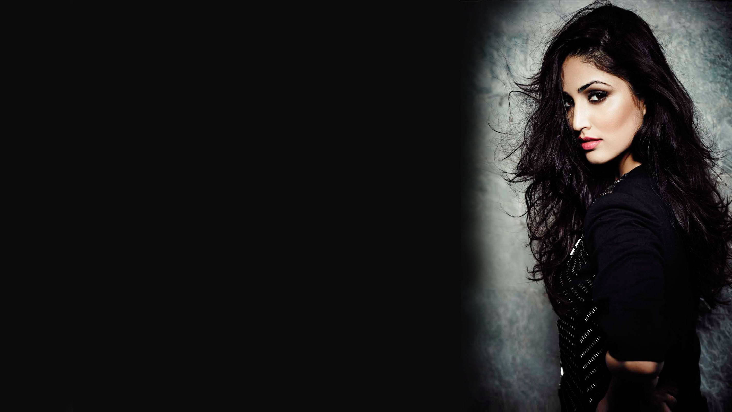 Yami Gautam, dark wavy hair, textured gray wall, 2K Desktop Wallpaper