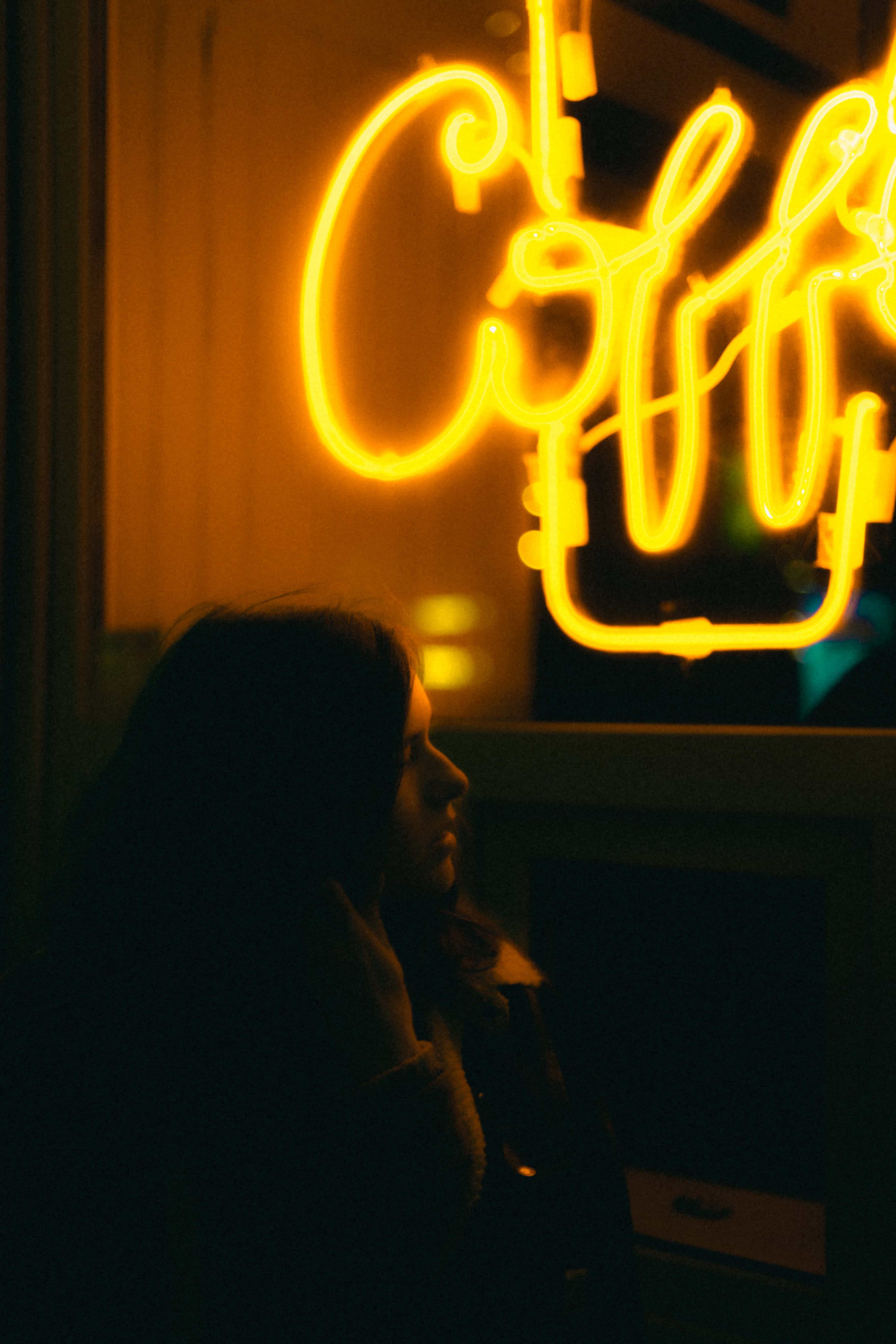 yellow neon coffee sign, silhouette of a person, dimly lit urban night scene, 5K Phone Wallpaper