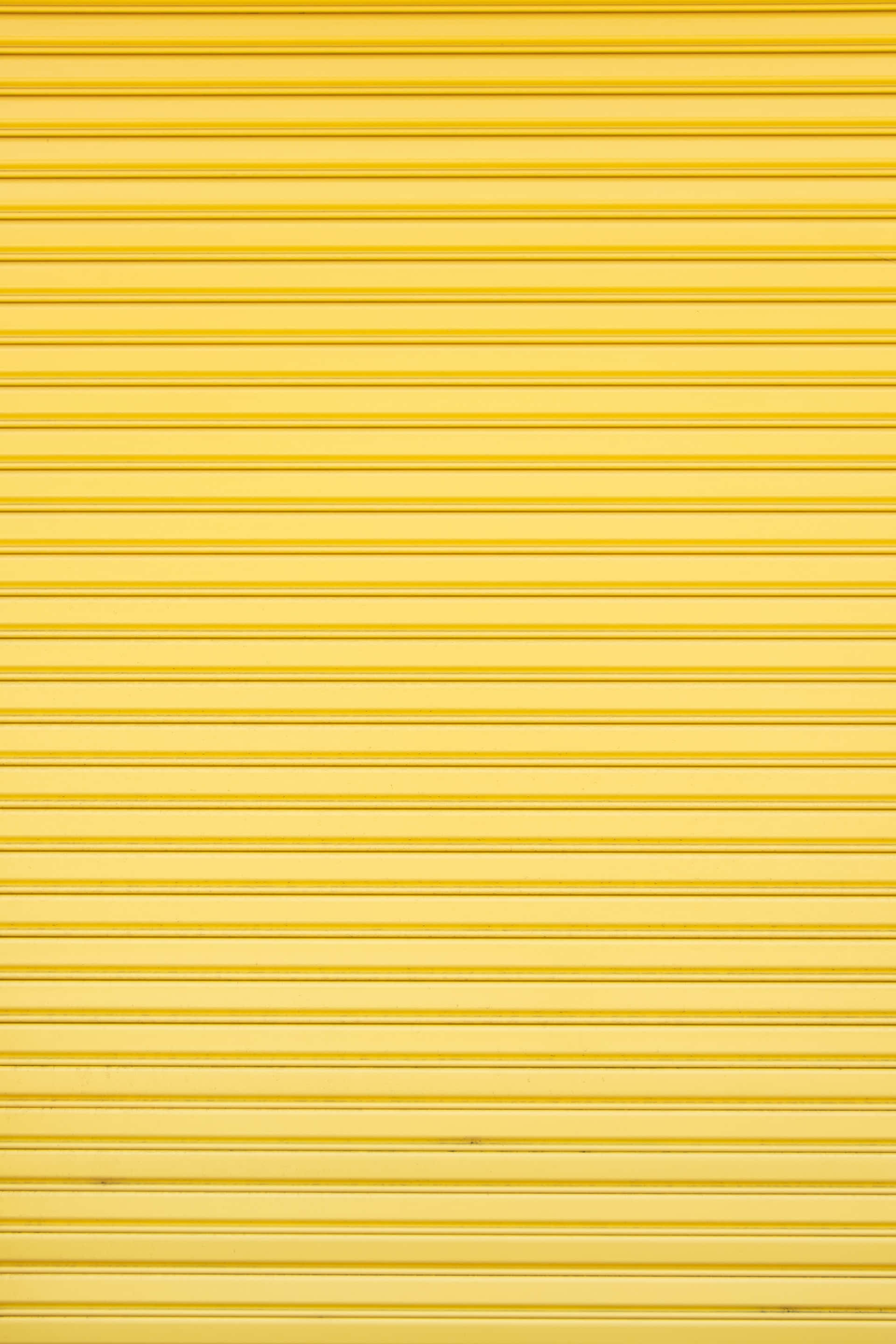 Vibrant Yellow Geometric Pattern, bright yellow metal roll-up door, horizontal ridges, 2K Phone Wallpaper