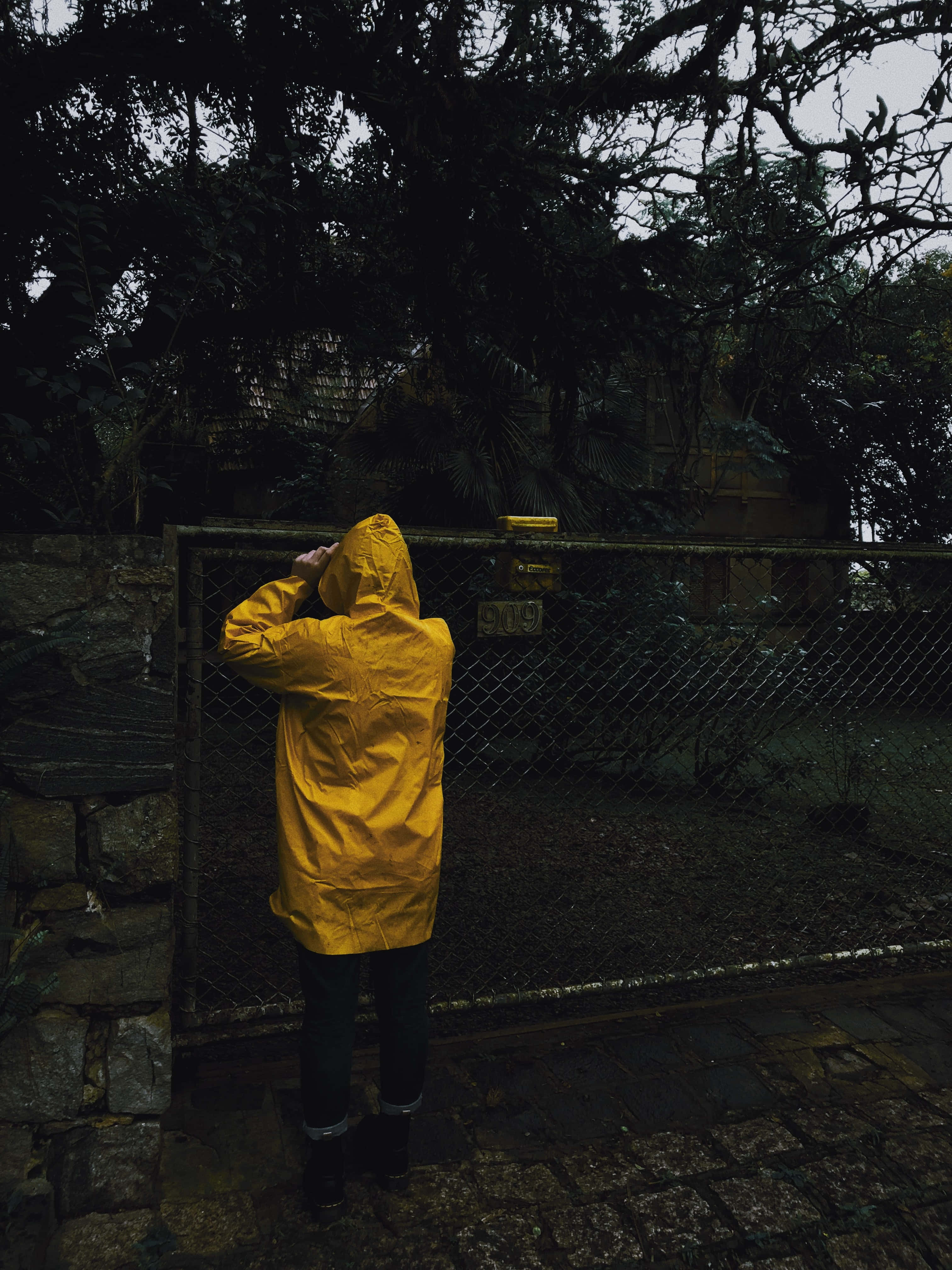 yellow raincoat, bright yellow raincoat, chain-link gate, 4K Phone Wallpaper