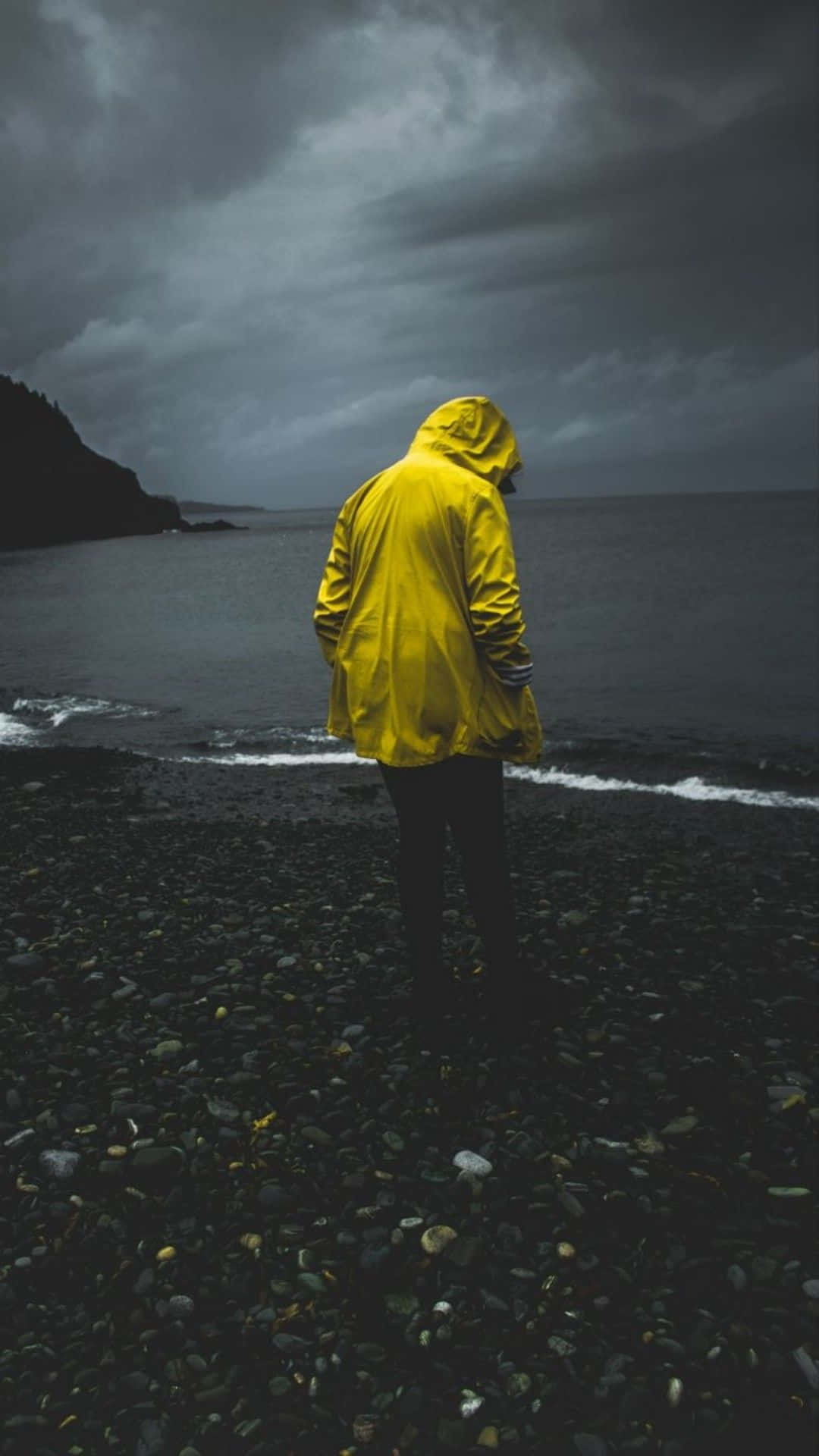 Yellow Raincoat, bright yellow raincoat, dark pebble beach, Full HD Phone Wallpaper