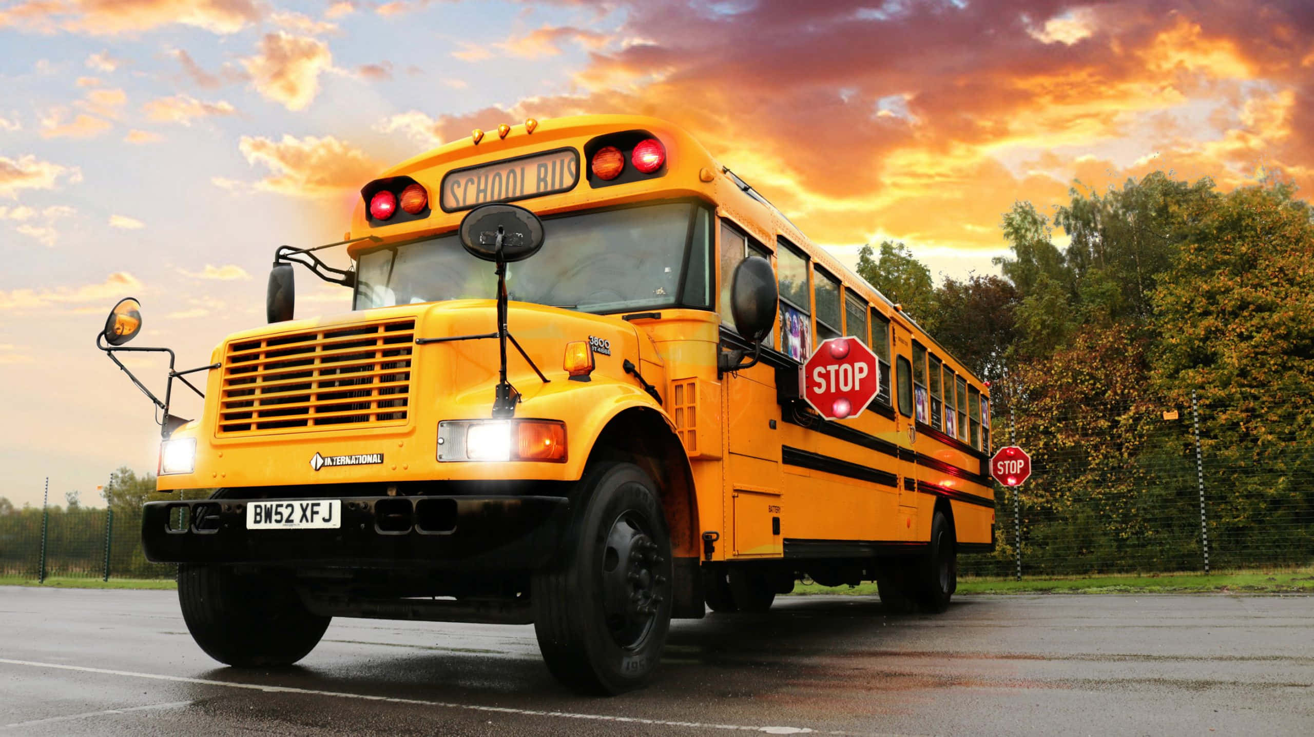 Yellow School Bus, stop signs extended, wet road, 2K Desktop Wallpaper