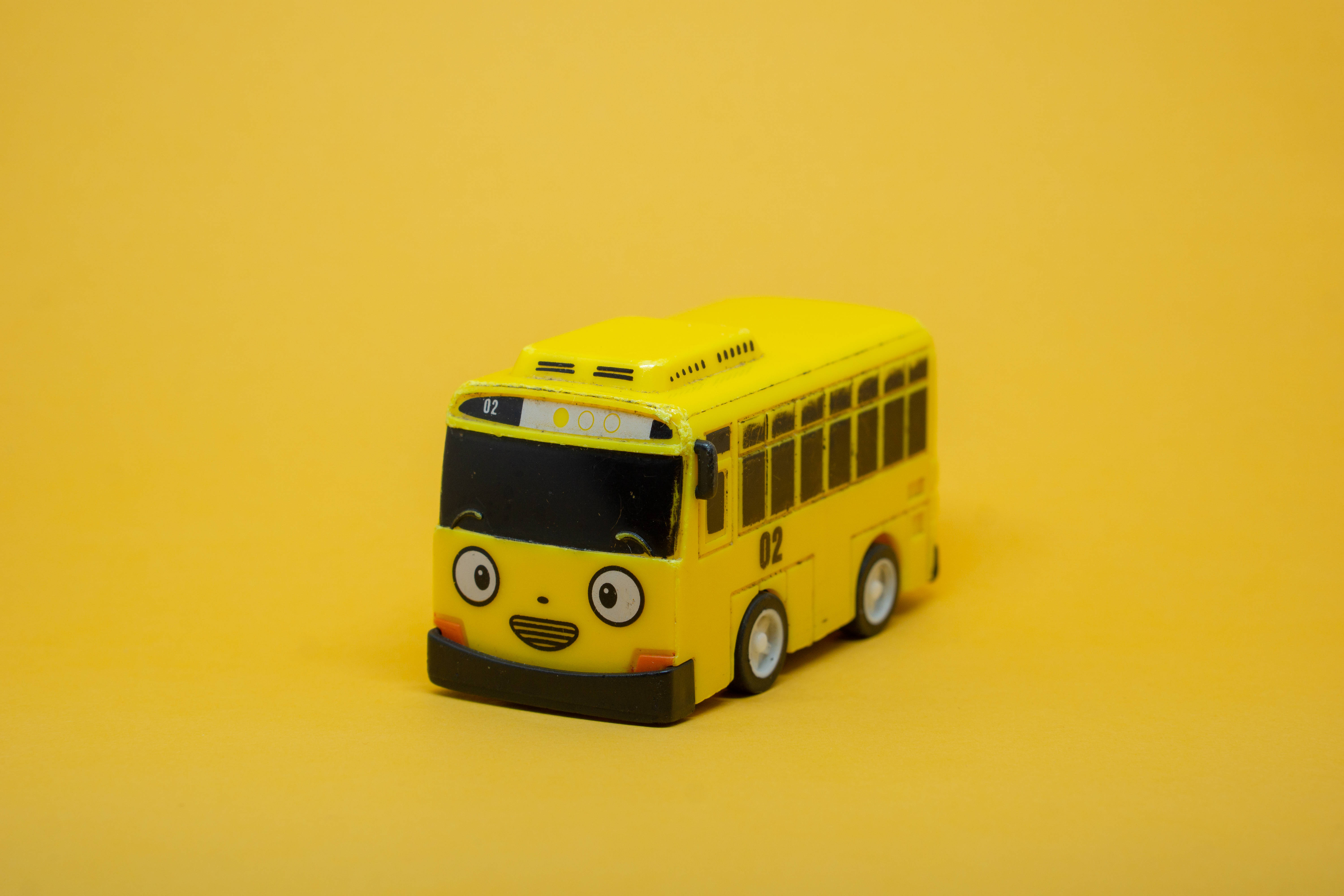 educational yellow toy bus, cheerful yellow, cartoon eyes, 5K Desktop Wallpaper