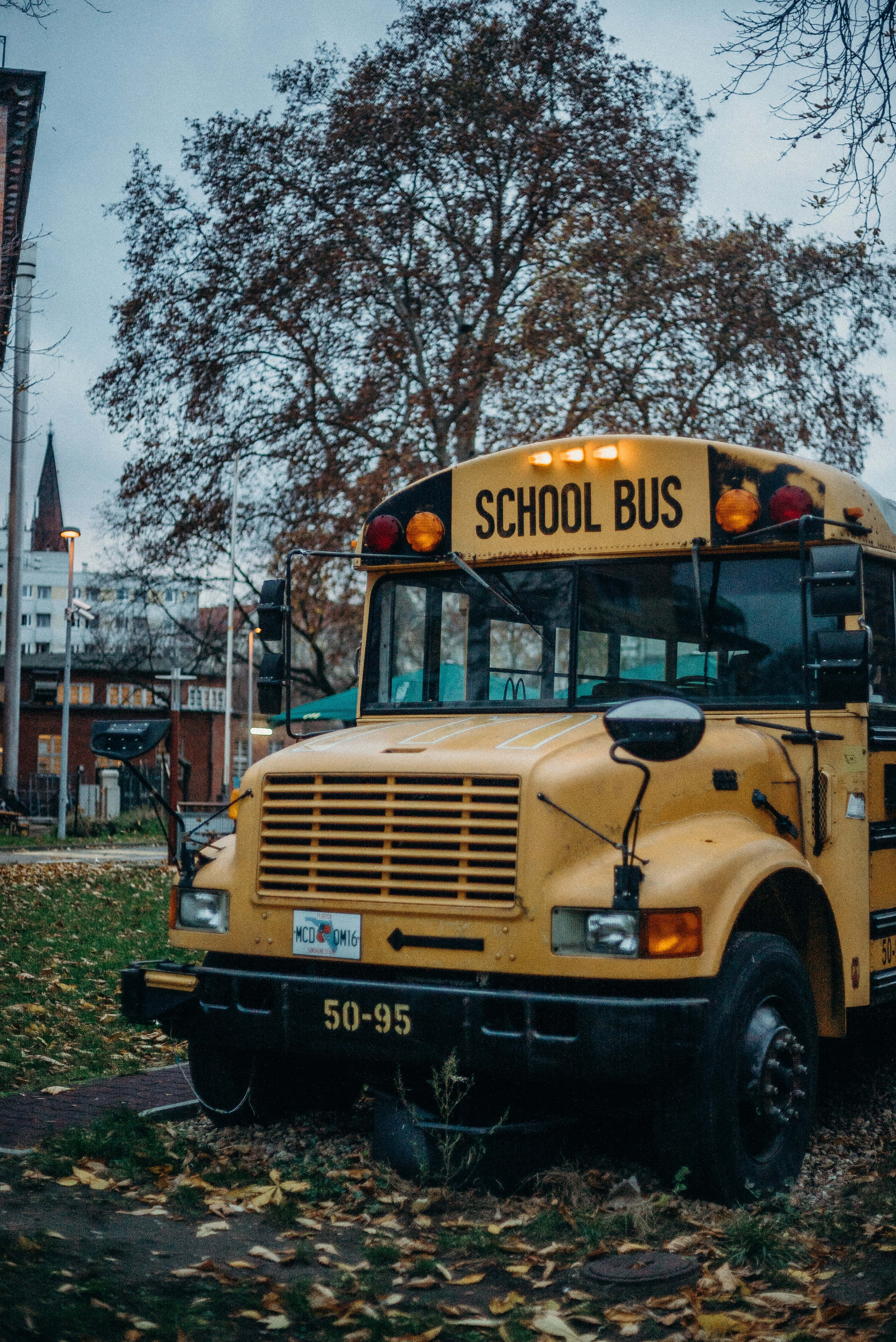 Yellow School Bus, autumn season, leaf-strewn sidewalk, 4K Phone Wallpaper