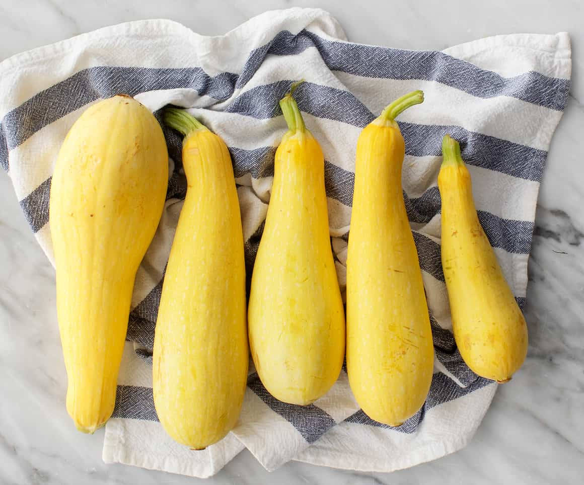 long yellow squash, striped kitchen towel, marble surface, SD Desktop Wallpaper
