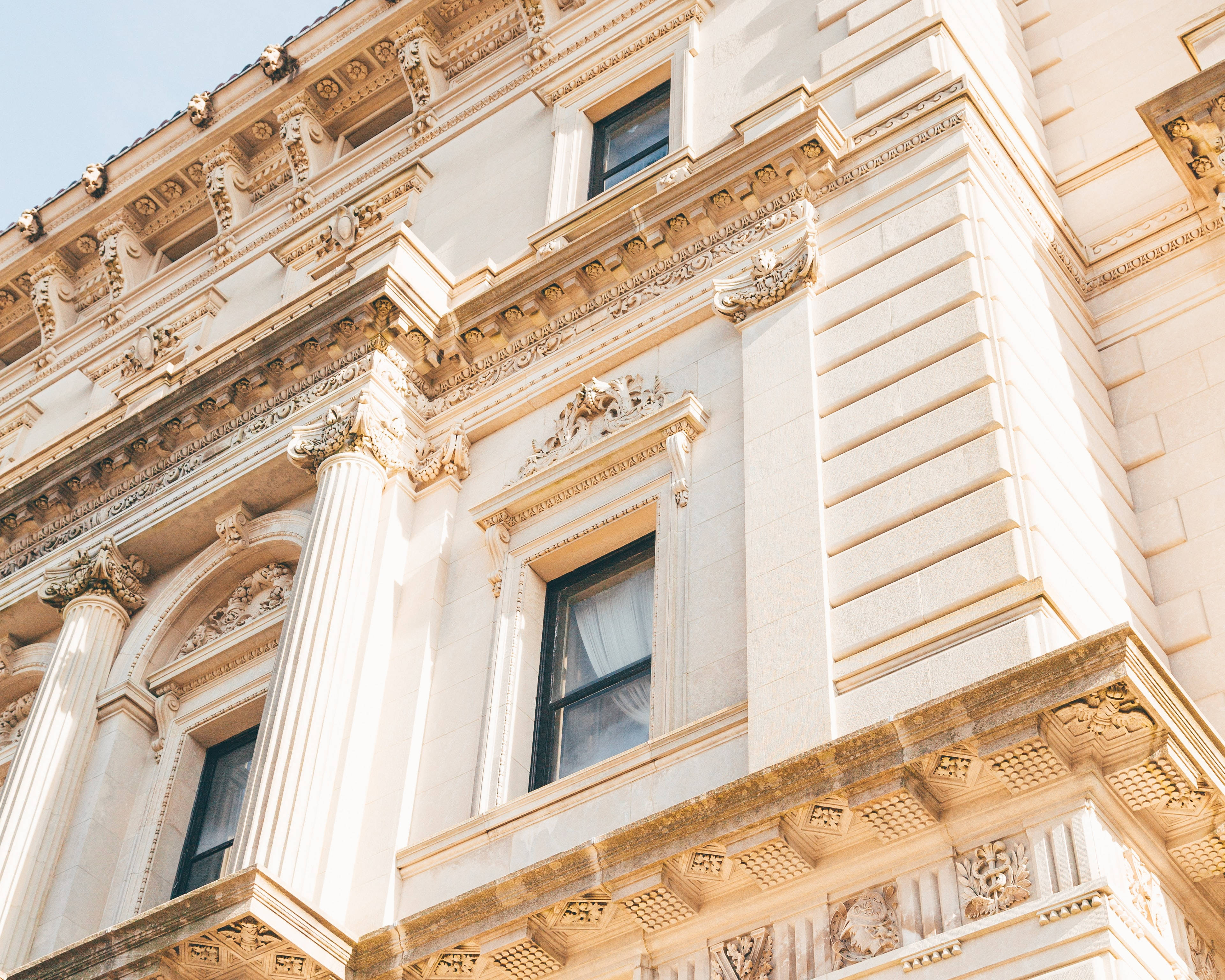 beige building facade, gold trim columns, detailed carvings, 4K Desktop Wallpaper
