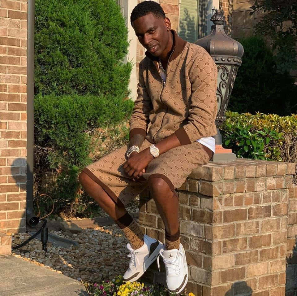 Young Dolph, brown patterned tracksuit, brick pillar, SD Desktop Wallpaper
