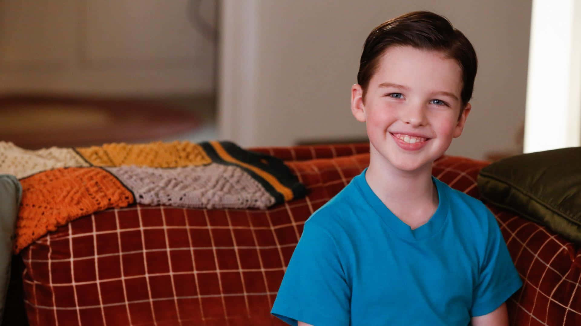 Young Sheldon, blue tshirt, red plaid couch, Full HD Desktop Wallpaper