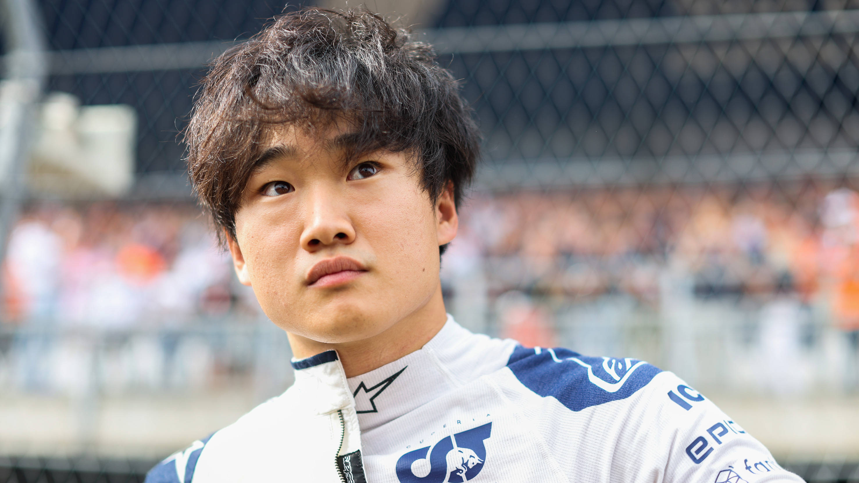 Yuki Tsunoda, white and blue racing suit, stadium backdrop, 2K Desktop Wallpaper