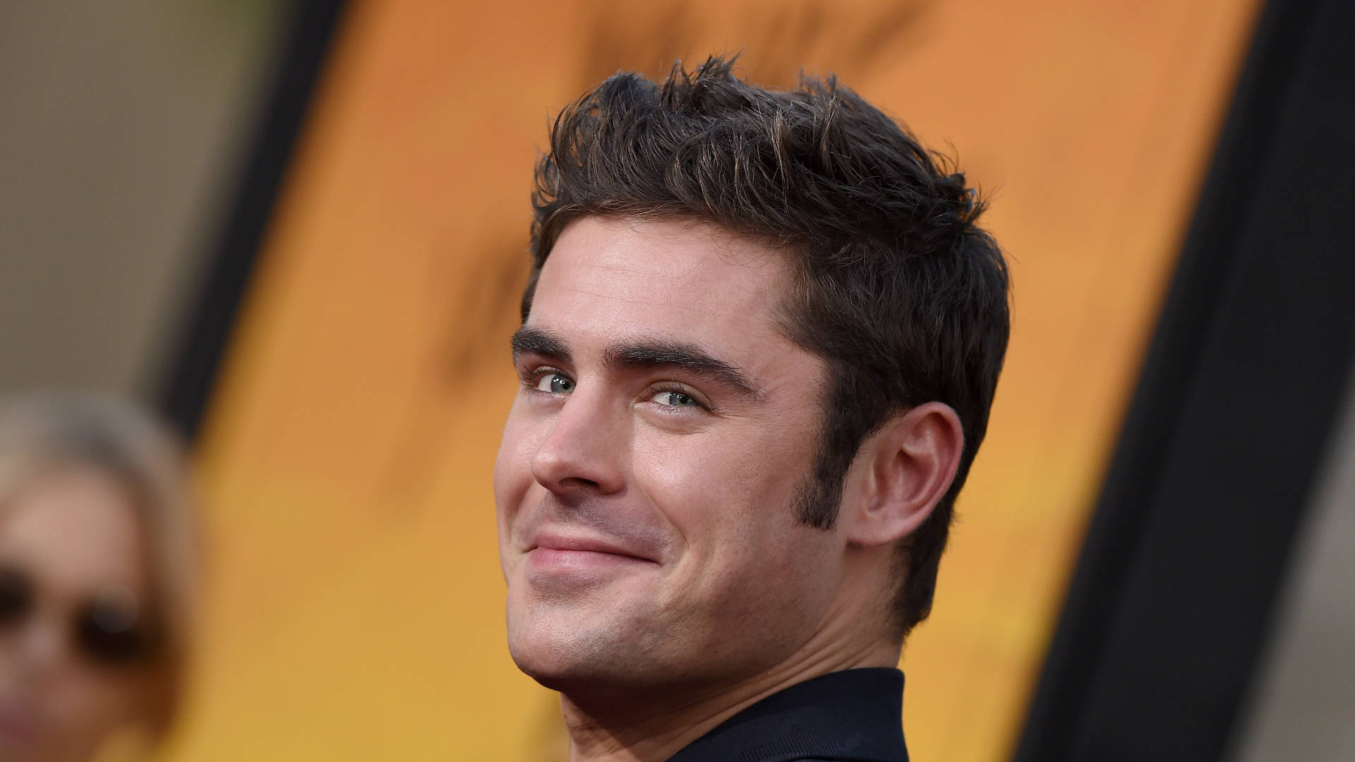 Zac Efron, dark hair, warm orange and black background, Full HD Desktop Wallpaper