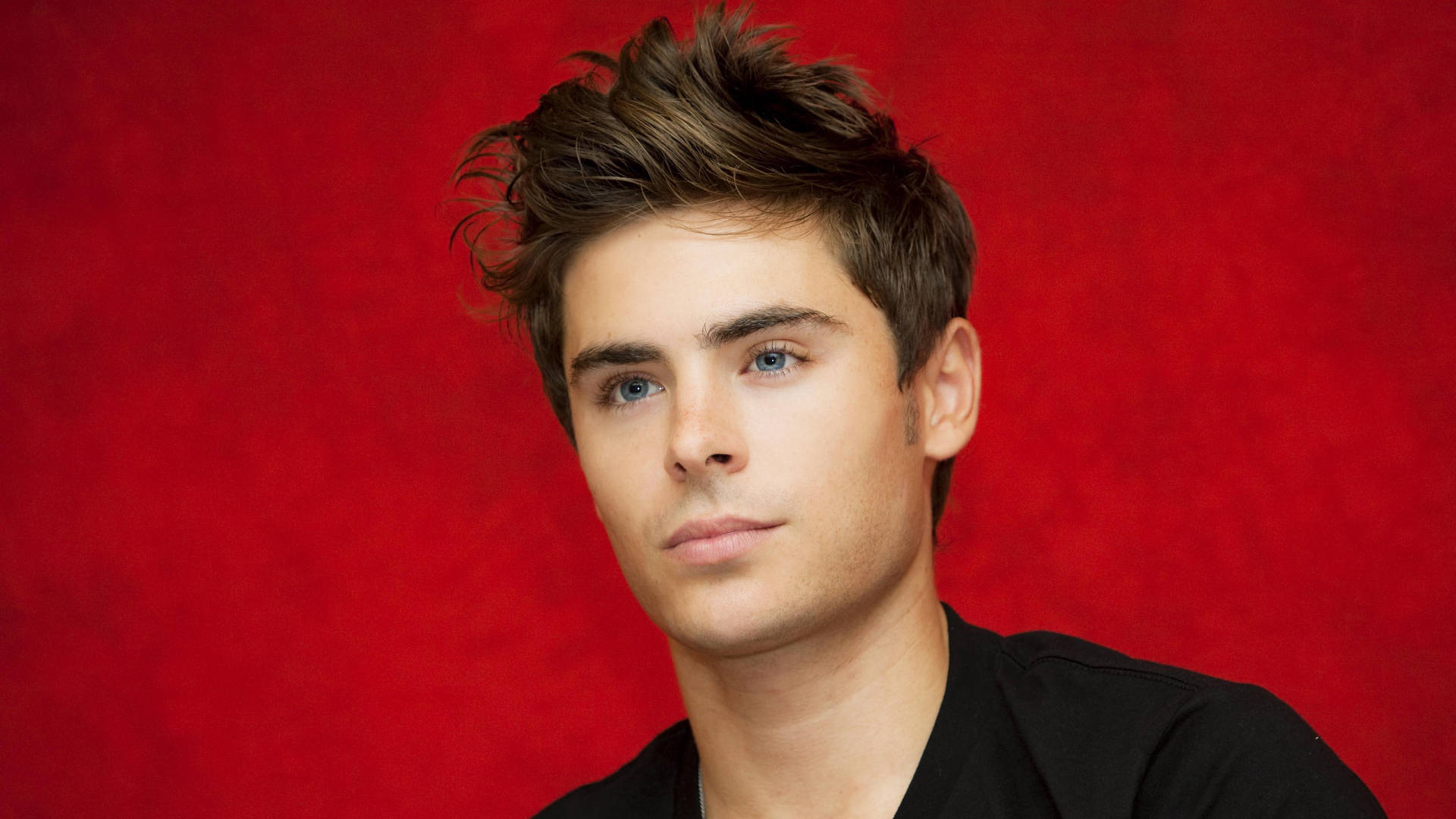 Zac Efron, red backdrop, tousled brown hair, Full HD Desktop Wallpaper