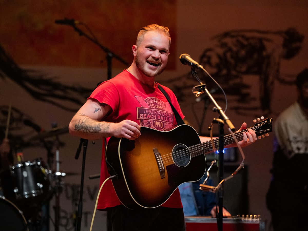 Zach Bryan, sunburst acoustic guitar, warm lights, SD Desktop Wallpaper