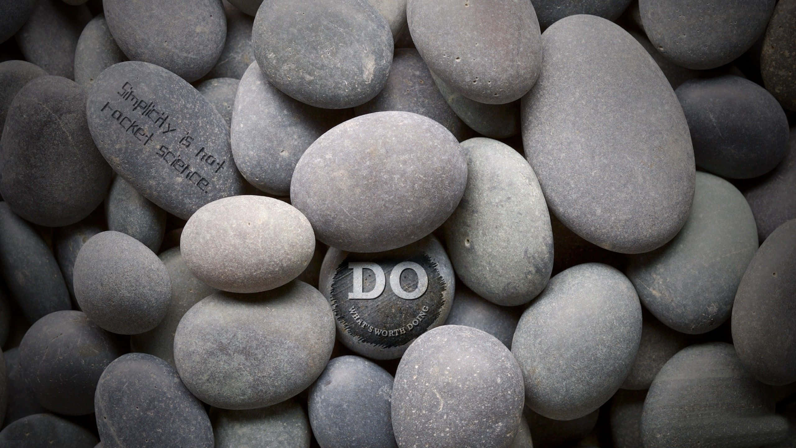 Zen Desktop, smooth gray river stones, engraved motivational phrases, 2K Desktop Wallpaper