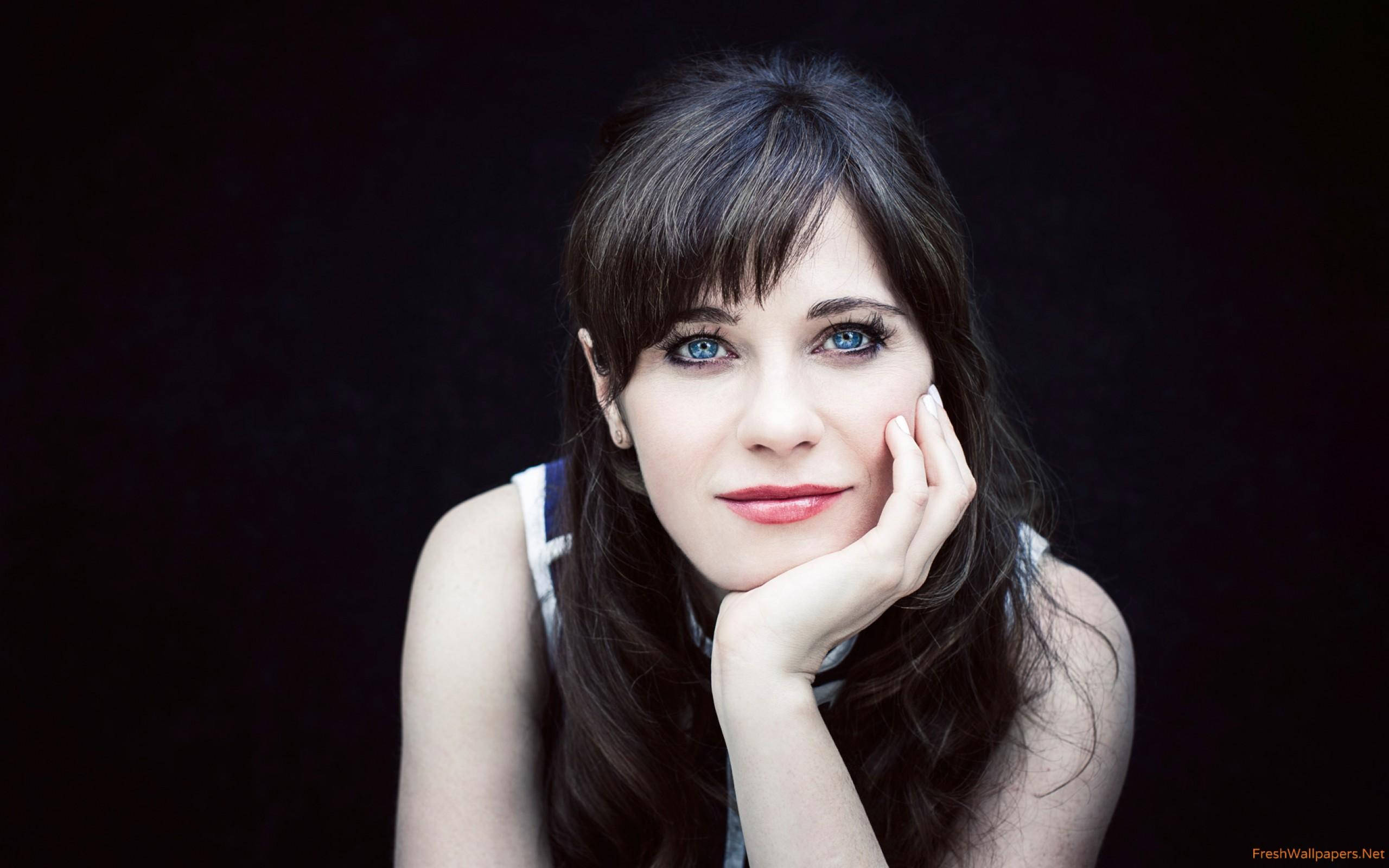 Zooey Deschanel, chin on hand, black background, 2K Desktop Wallpaper